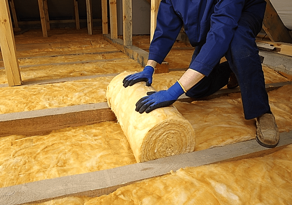 Bir işçi cam yünü ile ısı ve ses yalıtımı yapıyor